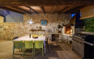 a kitchen with a table and chairs and a stove at Villa San Rocco with heated pool in Vodnjan