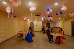 a group of people sitting at tables in a room with balloons at Via Chattarpur Enclave - Opposite Tivoli Garden in New Delhi
