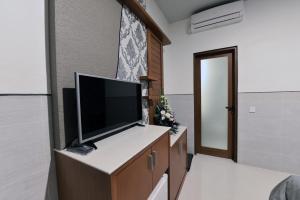 a room with a flat screen tv on a cabinet at Le Lima in Kuta