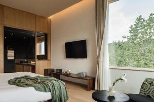 ein Schlafzimmer mit einem Bett und einem großen Fenster in der Unterkunft 西坡劳岭良室民宿 in Wukang