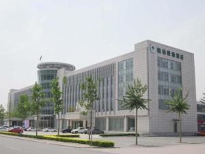 a large building with a parking lot in front of it at GreenTree Inn Tianjin Wuqing Distric Bohai Market in Dadunqiu