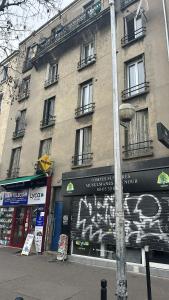 a pole on the side of a building with graffiti at Le Petit nid cocooning - Studio chaleureux et élégant in Aubervilliers