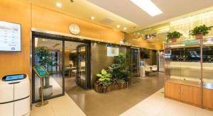 an office building with plants and a clock on the wall at Jinjiang Inn Beijing Huairou Qingchun Road Wanda Plaza in Huairou