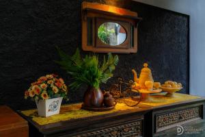 BrosotHomestay Alenay Resort Kulonprogo的一张桌子上挂着镜子和鲜花