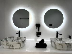 two sinks in a room with two mirrors at U PARADISU VILLAS - Private Pool in Jambiani