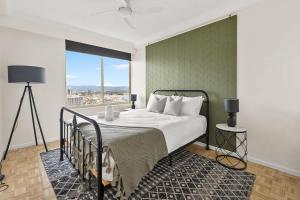 a bedroom with a bed with a green wall at Luxury 3BR Gold Coast Stay Ocean and City Views in Gold Coast