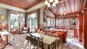 a kitchen with a table and chairs and a kitchen with windows at Mt Eden Victorian Villa in Auckland