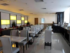 ein Esszimmer mit weißen Tischen und weißen Stühlen in der Unterkunft Lavande Hotel Xian Gaoxin Branch in Xi'an