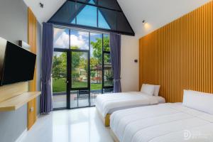 BrosotHomestay Alenay Resort Kulonprogo的一间带两张床、一台电视和一扇窗户的卧室 更多34张照片