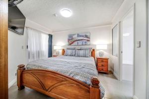 Un dormitorio con una gran cama de madera en una habitación. en Poolside Escape at Alexandra Headland, en Alexandra Headland 9 fotos más