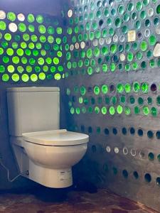 a bathroom with a toilet in a wall with green bubbles at Mannam desert dome in Dahab