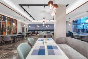 una sala da pranzo con un lungo tavolo e sedie di Yitel Collection Hefei Changjiang Hotel Sanxiaokou Metro Station a Hefei