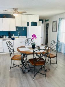 a kitchen with a table and chairs and a kitchen with white cabinets at Garden Cottage in Langley