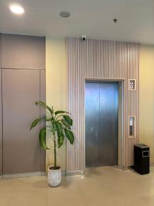 Eine Topfpflanze in einem Flur neben einem Aufzug in der Unterkunft Alltrue Lite Hotel Nagoya Hill Batam in Nagoya