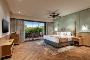 a bedroom with a bed and a balcony at WelcomHeritage Akashganga Heritage Hills Resort & Spa  +7 photos