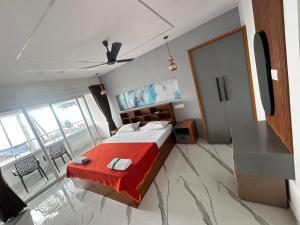 a bedroom with a large bed with a red blanket at Karthik Villa in Varkala