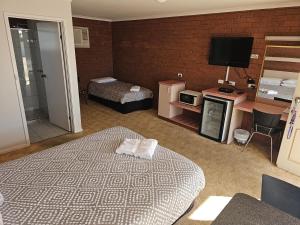 a hotel room with a bed and a television at Star Hotel Rutherglen in Rutherglen