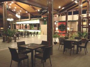 una sala da pranzo con tavoli e sedie in un edificio di Pearlmont Hotel a Camaman