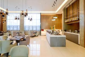 un ristorante con tavoli e sedie e un bar di City Comfort Inn Hotel Nanning Nanhu Park Macun Metro Station a Nanning
