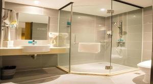 un bagno con doccia in vetro e lavandino di City Comfort Inn Hotel Nanning Nanhu Park Macun Metro Station a Nanning Altre 73 foto