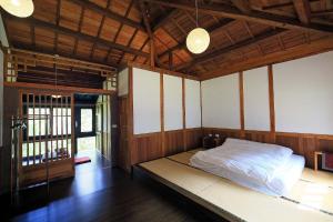 - une chambre avec un lit dans une pièce dotée de plafonds en bois dans l'établissement Sun Moon Home, à Yuchi