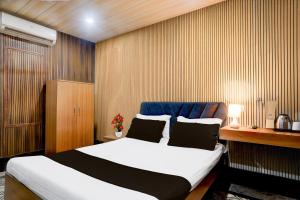 ein Schlafzimmer mit einem Bett und einer Holzwand in der Unterkunft Hotel O Nepali Mandir Bus Terminal Formerly Hotel Aaghnya in Guwahati