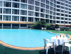 uma piscina com mesa e cadeiras e um edifício em Golden Lustre Hotel em Hong Kong