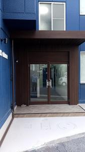 un ingresso di un edificio blu con una porta a vetri di BlueHouse a Hiroshima