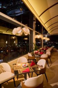 a restaurant with tables and chairs and a large window at The IRIS SIGNATURE HOTEL AND SPA in Can Tho