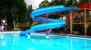 WanasariSelabintana Conference Resort的游泳池中的蓝色水滑梯