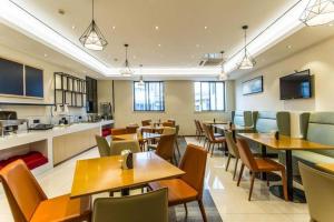 a restaurant with tables and chairs and a kitchen at City Comfort Inn Nanning Dongge Yuanhu Road 1st Affiliated Traditional Chinese Medicin Hospital in Nanning