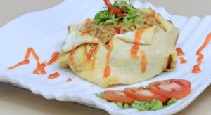 un piatto bianco con un pezzo di cibo con pomodori di Fizz Hotel Lombok a Tanjungkarang