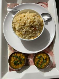 ein Teller mit einer Schüssel Reis und drei Schüsseln mit Fisch und Gebäck in der Unterkunft Gangamaya Homestay Darjeeling in Darjeeling + 36 Fotos