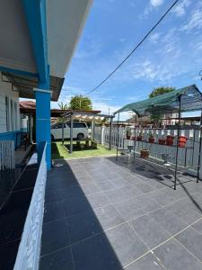 a porch of a house with a fence and a car at Chegebu Homestay in Kampong Beringin