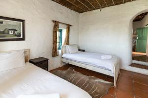 una camera da letto con due letti in una stanza di Die Jaghuisie at Blombosch Game Farm a Yzerfontein