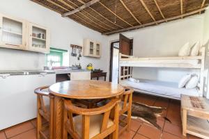 una cucina e una sala da pranzo con tavolo e letti a castello di Die Jaghuisie at Blombosch Game Farm a Yzerfontein