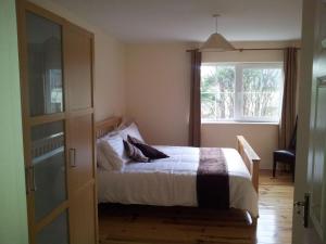 een slaapkamer met een bed en een raam bij 15 Sheen View Kenmare Co Kerry in Kenmare