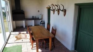 una sala da pranzo con tavolo e sedie in legno di Die Jaghuisie at Blombosch Game Farm a Yzerfontein