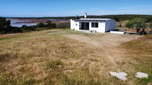 una piccola casa bianca in cima a un campo di Die Jaghuisie at Blombosch Game Farm a Yzerfontein