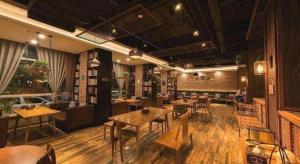 ein Restaurant mit Tischen und Stühlen in einem Raum in der Unterkunft James Joyce Coffetel Tianjin Railway Station Jinshiqiao Metro Station Branch in Tianjin