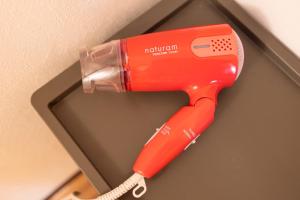 un secador de pelo rojo colgado en una pared en Guesthouse & Kitchen Hace - Vacation STAY 68911v, en Iwaki