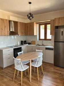 a kitchen with a wooden table and white chairs at Endless View 2 in Mythimna