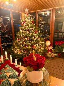 Un árbol de Navidad en una habitación con rosas y velas. en Cabana Din Poienita, en Poiana Brasov