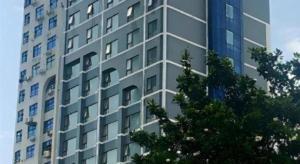 um edifício alto com uma árvore na frente em City Comfort Inn Changsha Tangshuili Fuyou em Changsha