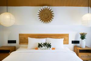 Un dormitorio con una gran cama blanca con almohadas blancas. en Ubud Dzen Villa 3, en Ubud