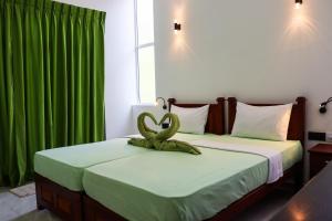 a room with two beds with green curtains at The Green Homestay - Galle in Galle +117 photos
