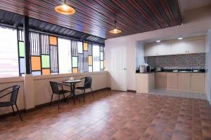 乌隆他尼At Home at Udon的一间有桌子、椅子和窗户的房间