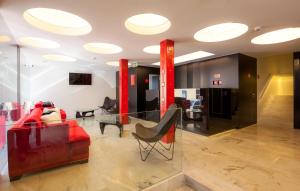 a living room with a red couch and a glass table at Faro Boutique Hotel in Faro