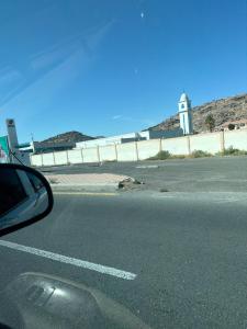 ein Seitenspiegel eines Autos auf einer Straße mit einem Leuchtturm in der Unterkunft وحدة سكنية in Ta'if