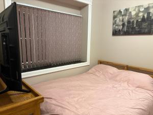 a bedroom with a bed and a television and a window at Vacation Home in Vancouver